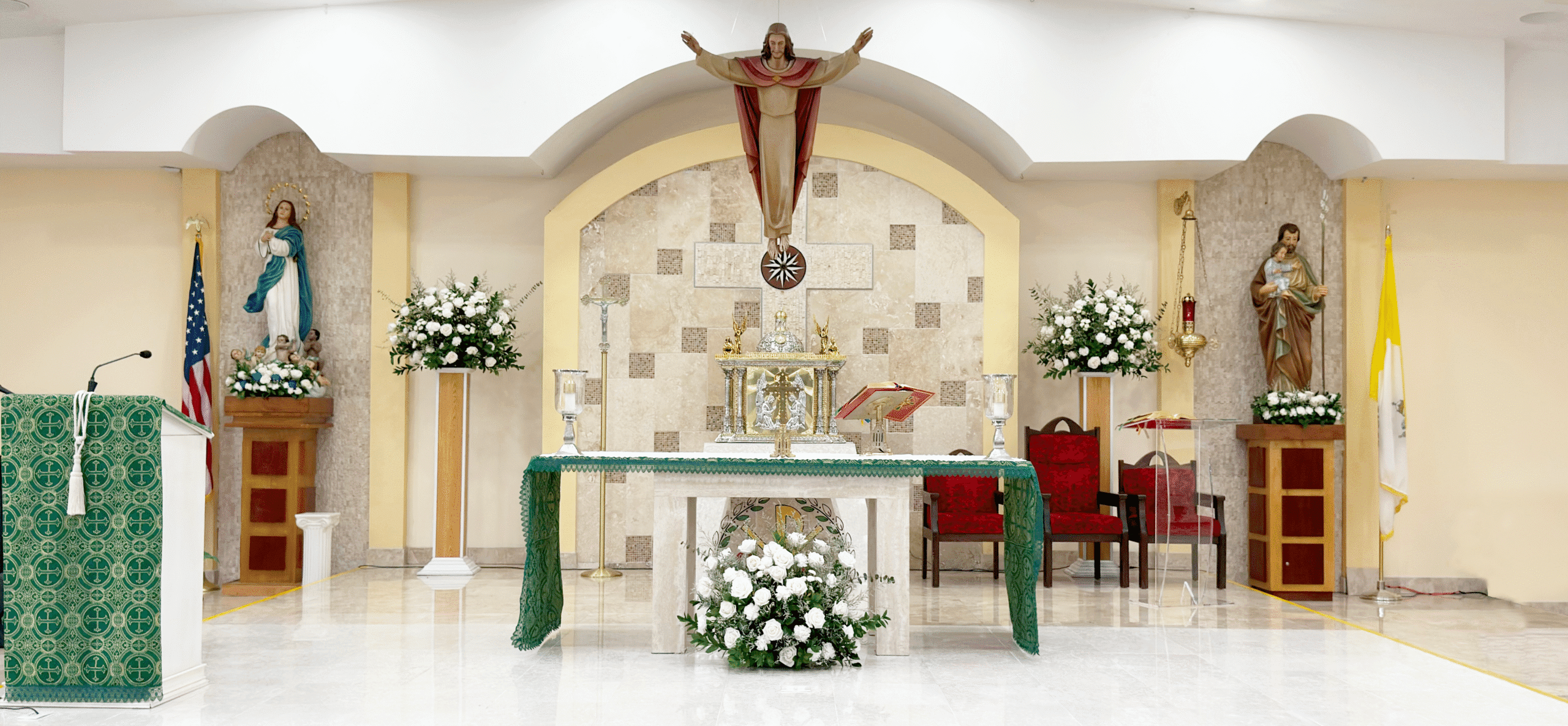 Santa Barbara Catholic Parish — Interior altar with the risen Christ, adorned with white flowers
